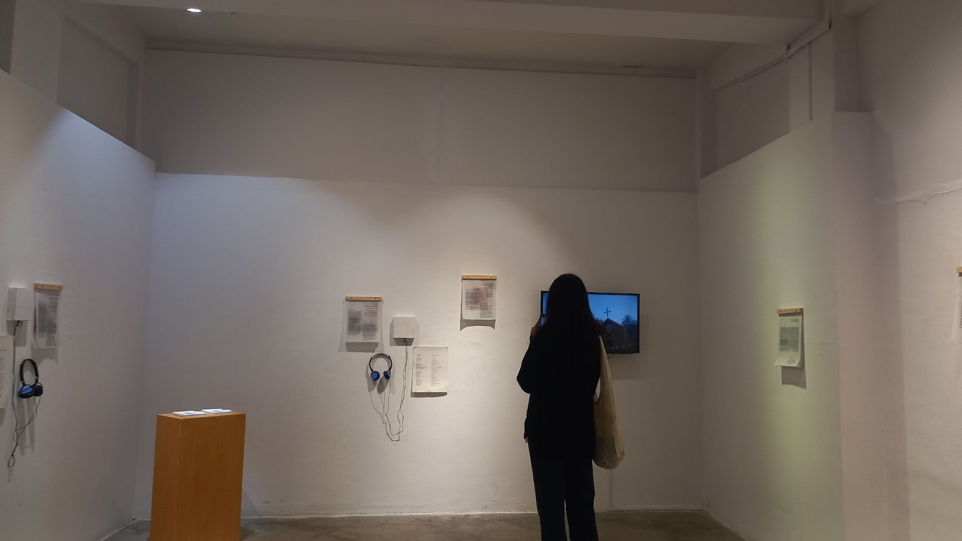 A visitor going through the exhibition work by Ahmed Alaqra