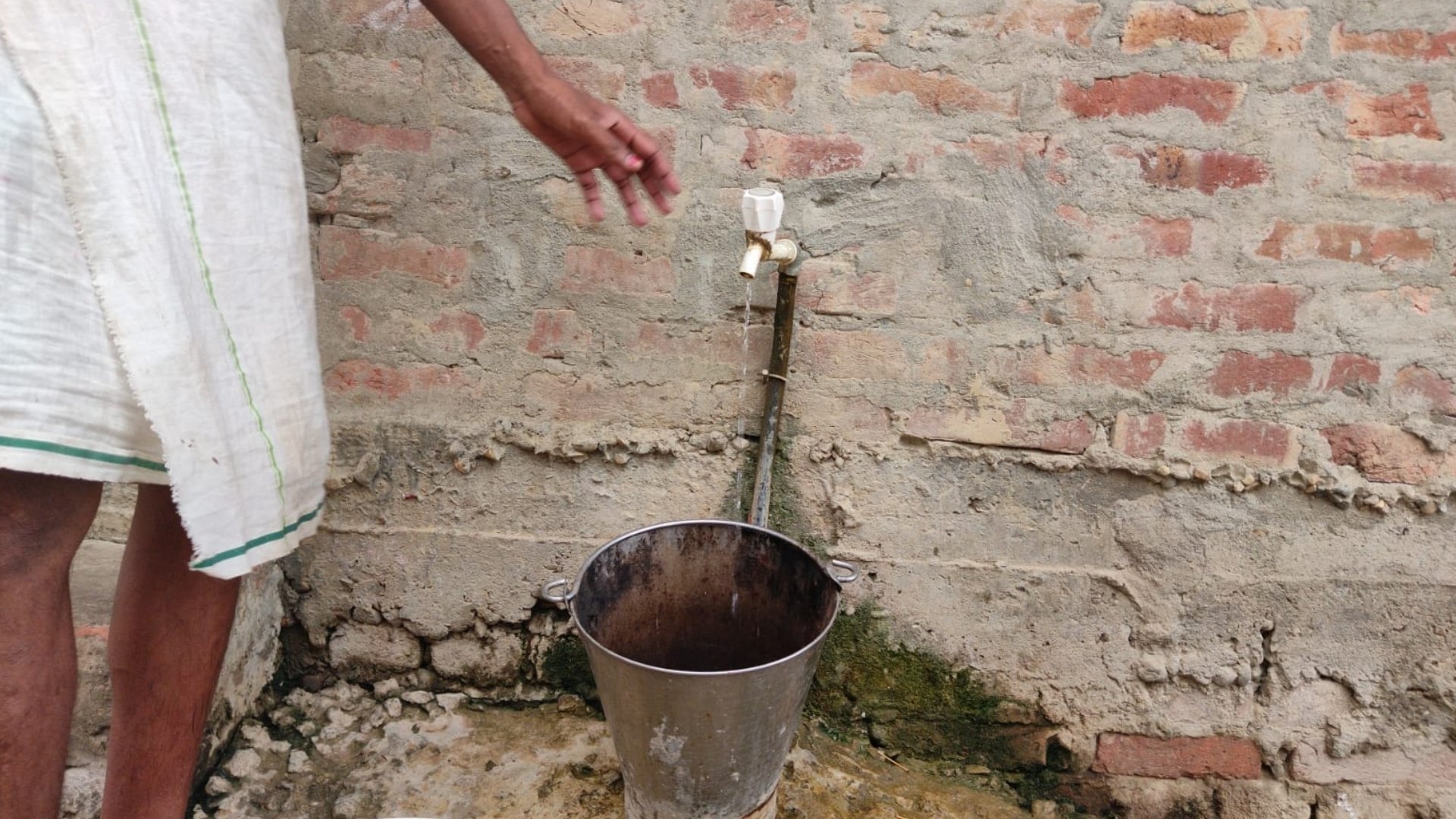 A person collects thin flowing water in their iron bucket in Nagwa, Birgunj Metropolitan City-16 | Photo Courtesy: Surya Narayan BK