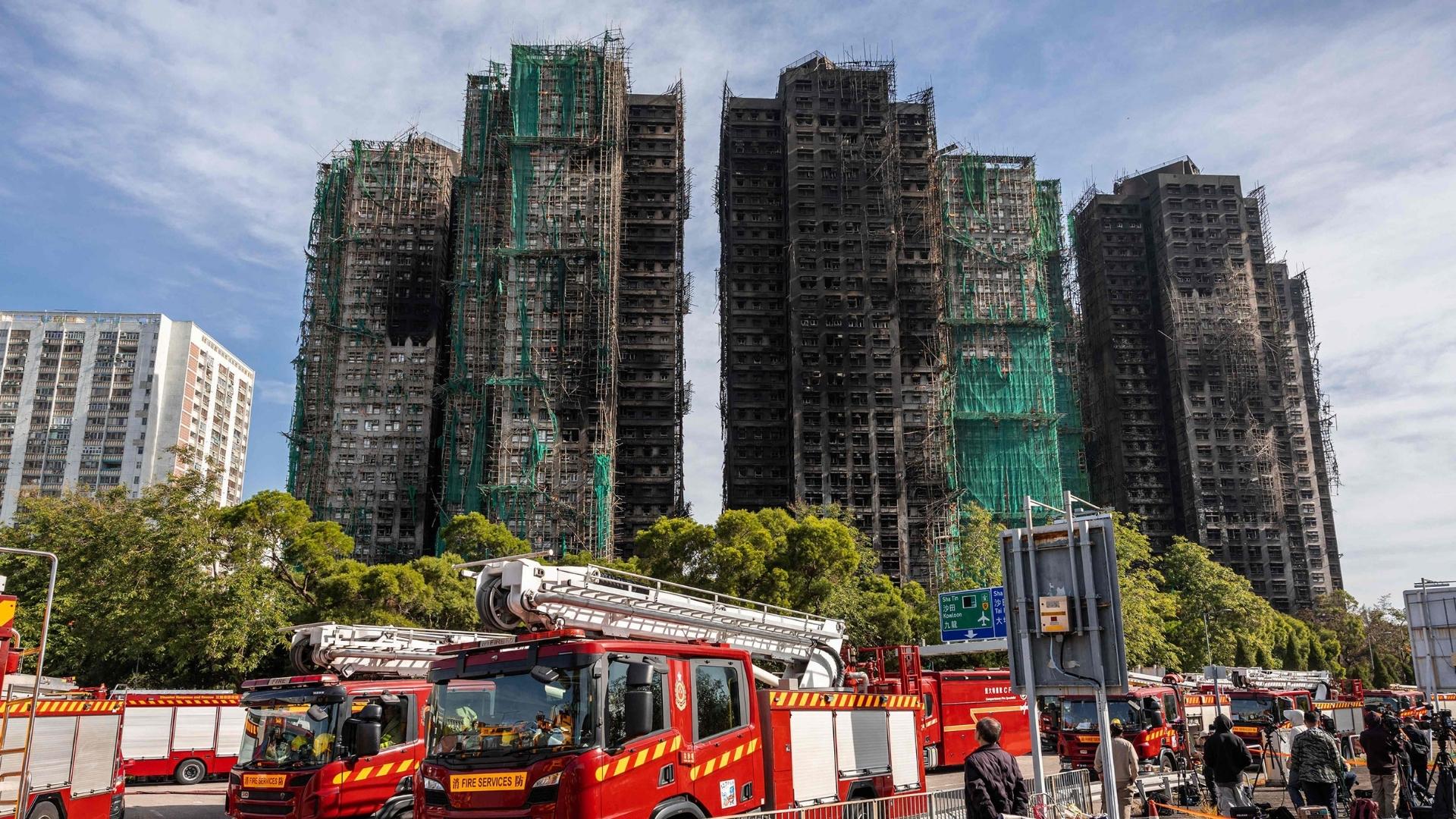 A man looking at the aftermath of a major fire that swept through several apartment blocks at the Wang Fuk Court residential estate in Hong Kong's Tai Po district on November 28, 2025 | Photo: Dale De La Rey/AFP